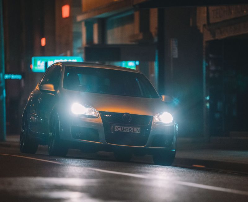 Bil med lys p&aring; om aftenen